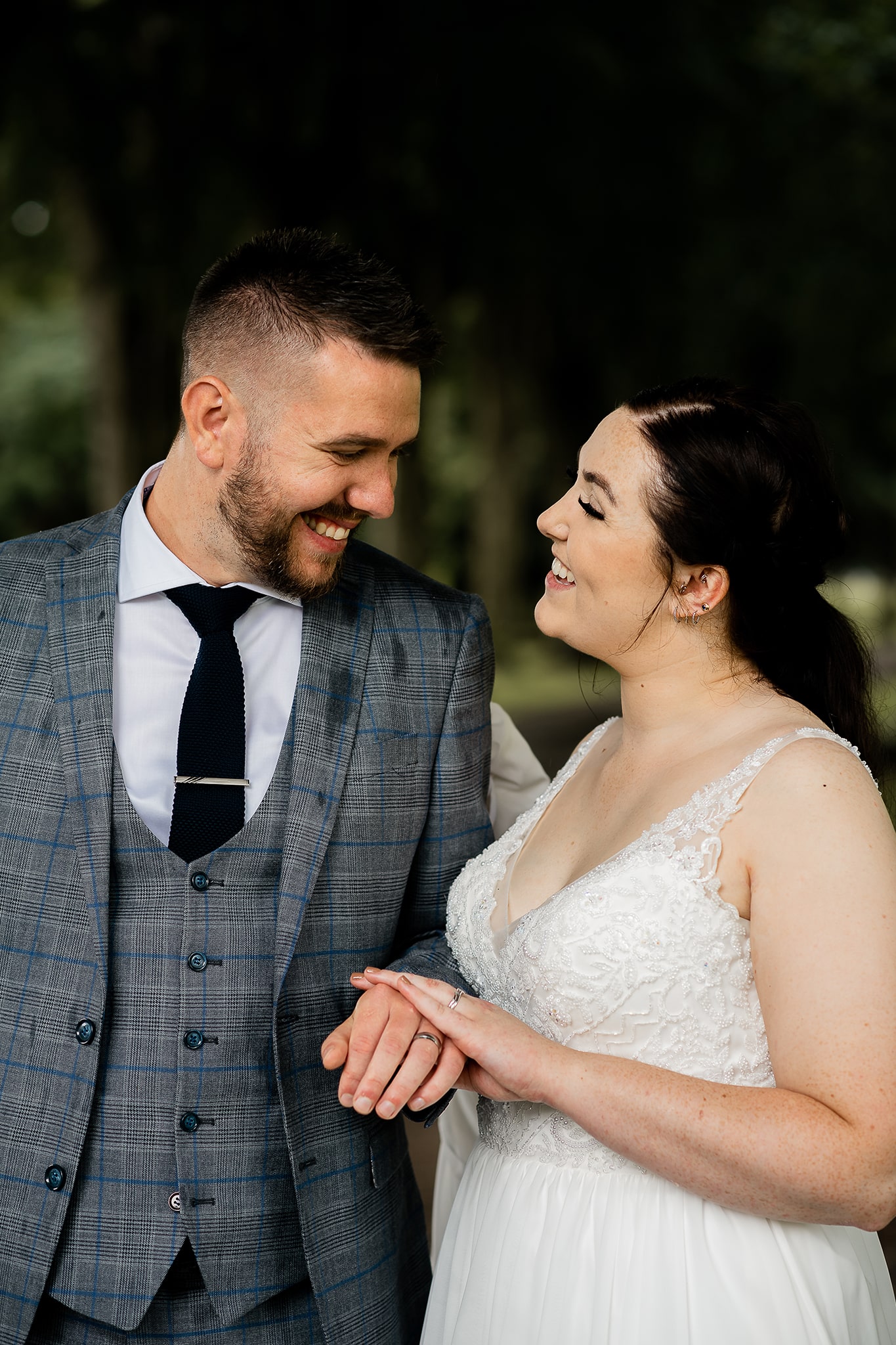 Wedding couple looking into each others eyes, smiling after slight rain